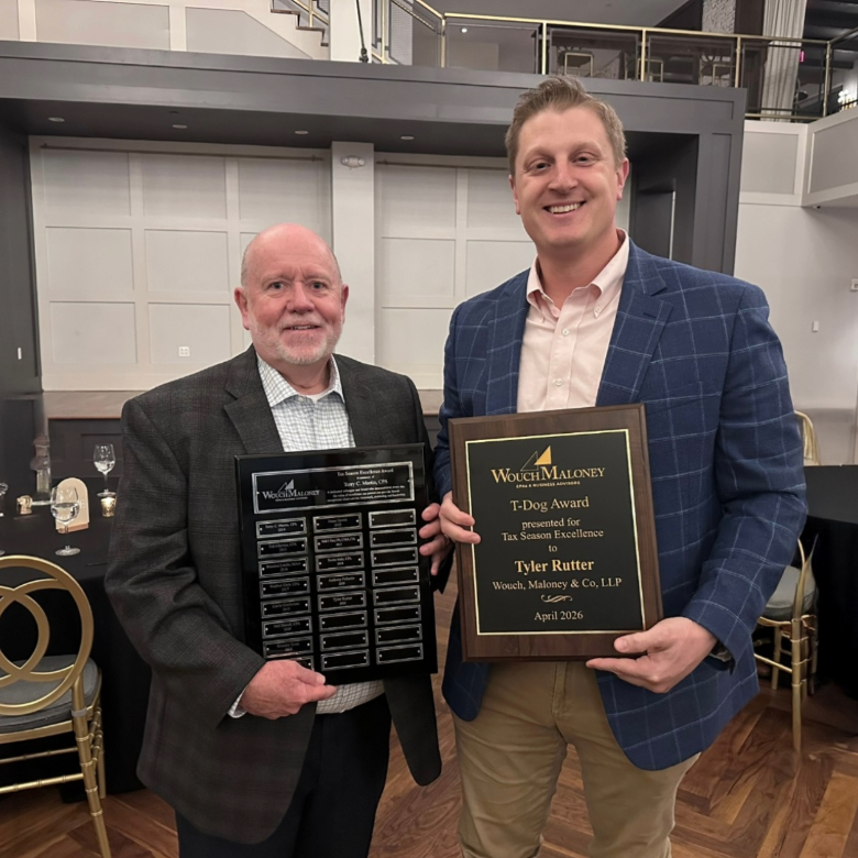 Two men holding award plaques
